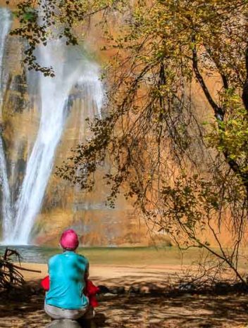 Woman lost in thought at the pool's edge of Lower Calf Creek Falls