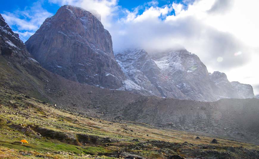 Tents are dwarfed by the mountains in this landscape