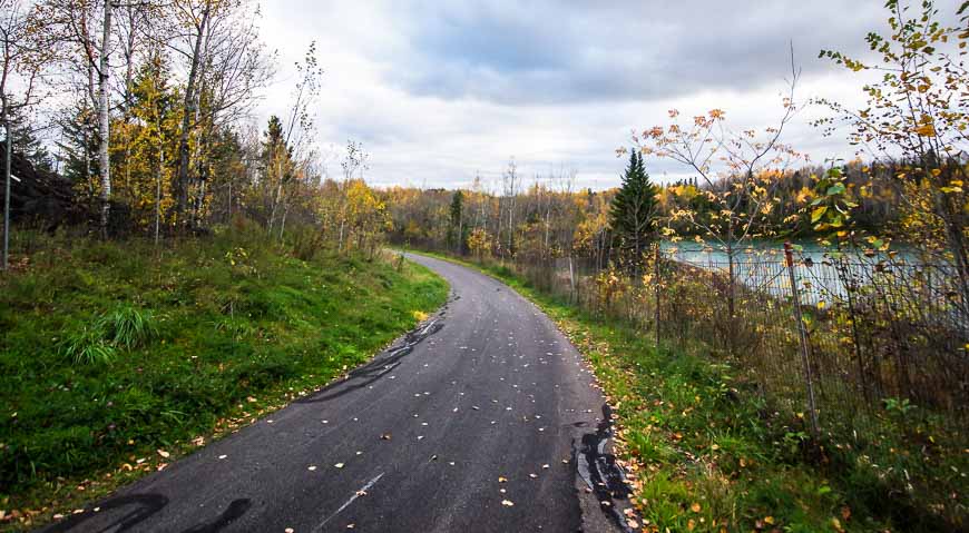 Cycling past the turquoise-coloured waters of the Iroquois Mine Pit