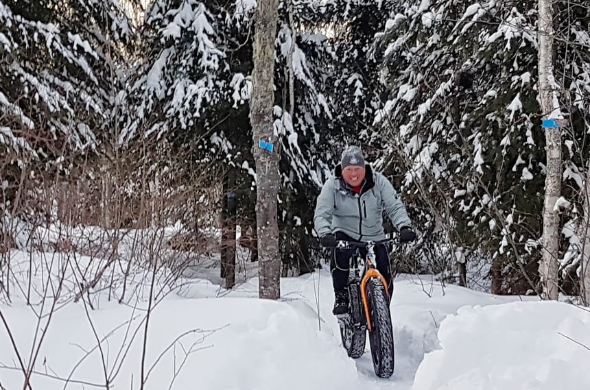 a man riding his fat bike bike in snow