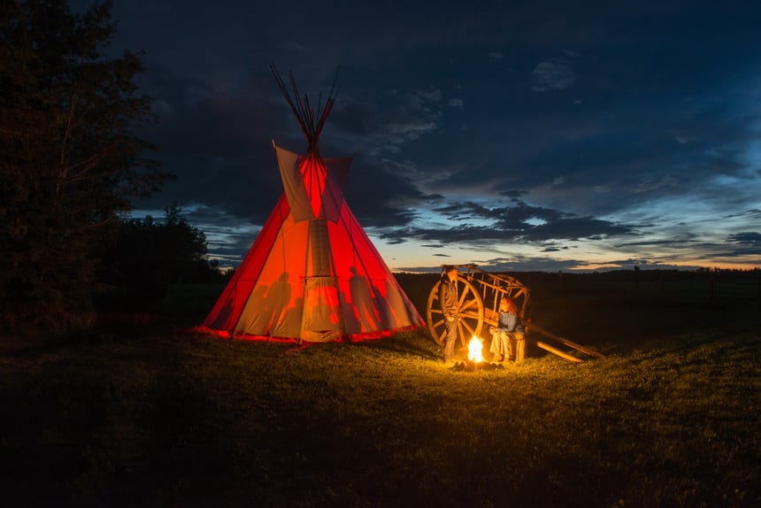 Red River Cart & glowing tipi at Rocky Mountain House National Historic Site in Alberta - Photo credit @Parks Canada/Scott Munn