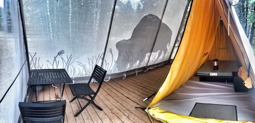 An inner tent with a bed and chairs and outer roomy, bug proof tent Riding Mountain National Park - Photo credit @Parks Canada/Eric Beaudoin