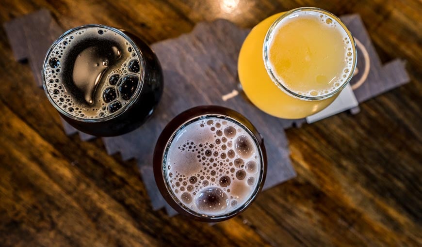 A flight of beers served on a map of the Okanagan