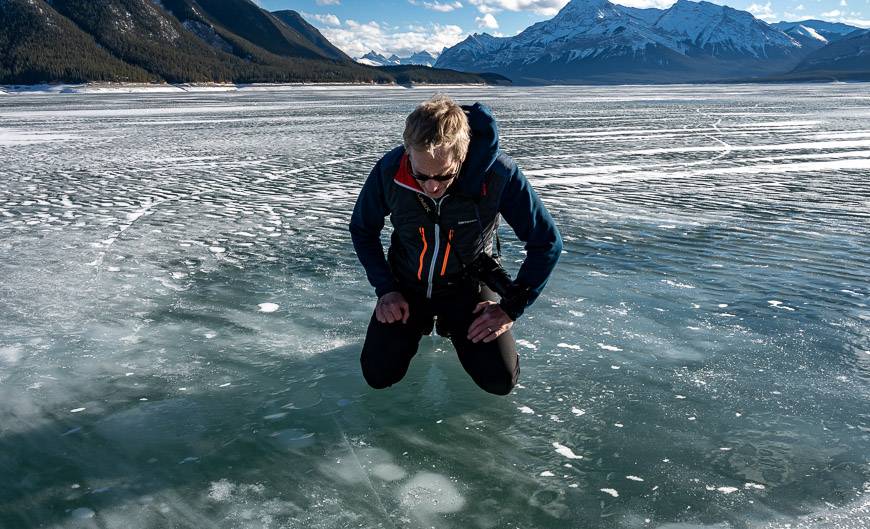 John inspects the last of Lake Abraham's bubbles in winter