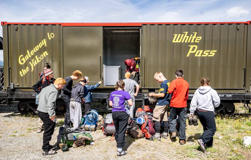 Hikers on the Chilkoot Trail picking up their packs in Carcross, Yukon Territory