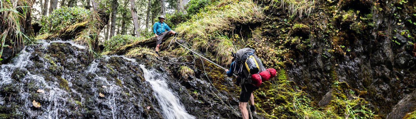 Hiker climbing small waterfall