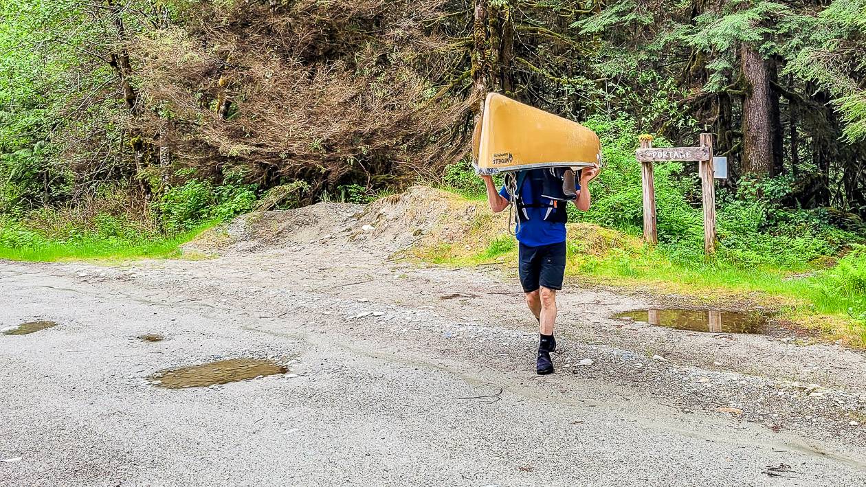 Crossing a logging road with a canoe on one's head