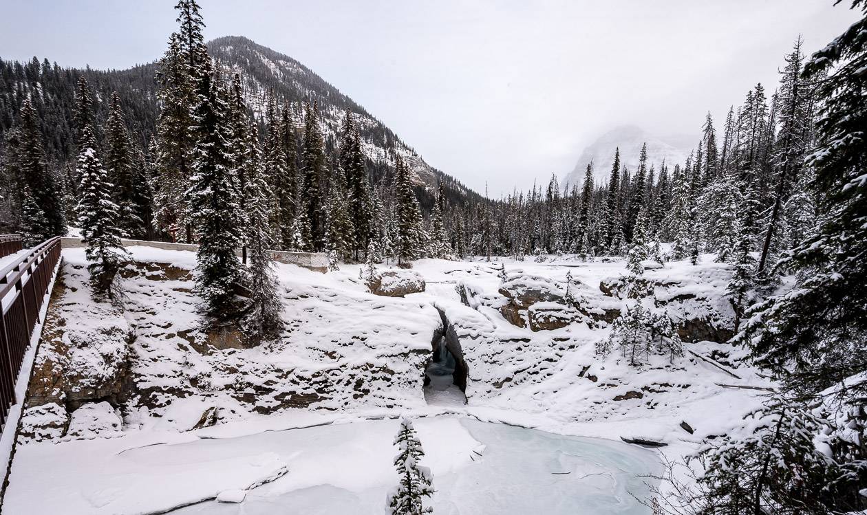 If the river is FROZEN SOLID you can walk into the chasm where the water runs but not sure I'd do it