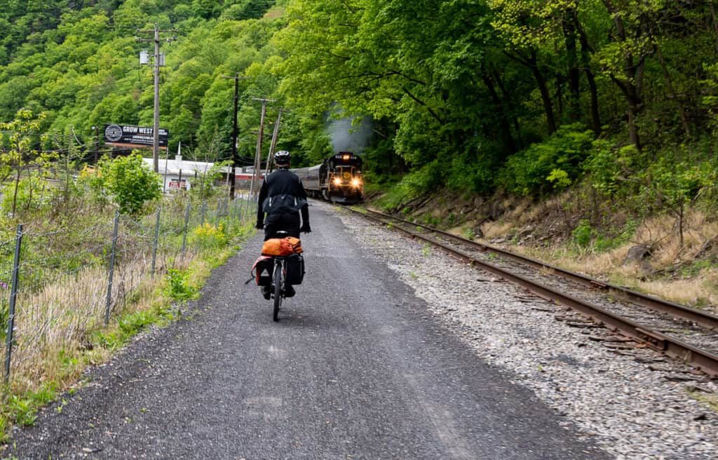 Biking past a train as we roll into Cumberland at the end of the Great Allegheny Passage bike ride
