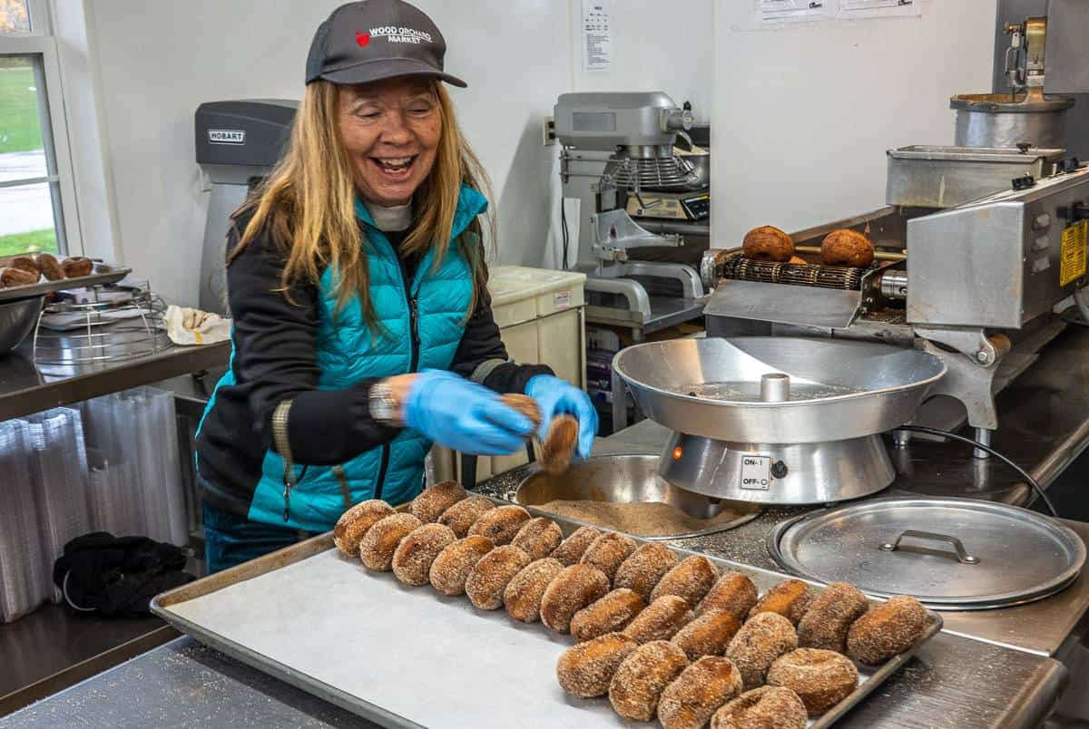 Dipping the fresh apple cider donuts into a hot cinnamon sugar mixture