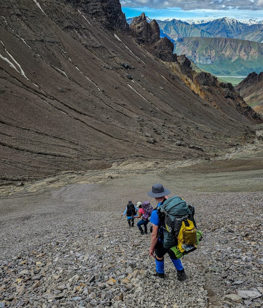 Descending a steep scree slope that moves with you in Kluane National Park