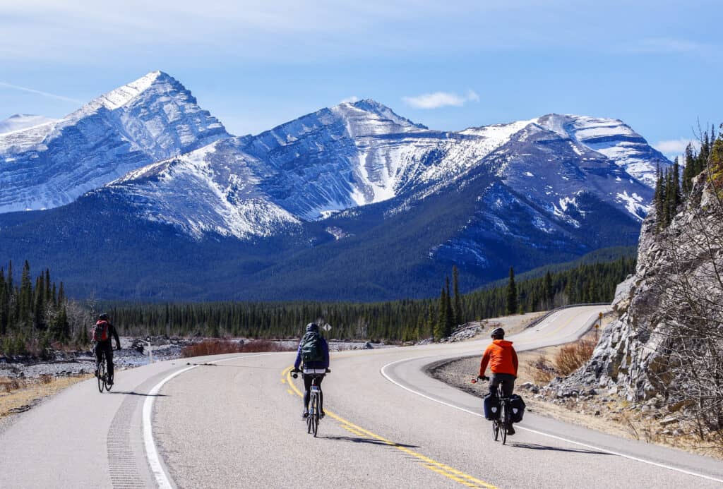 Picture of people biking with mountains in the background