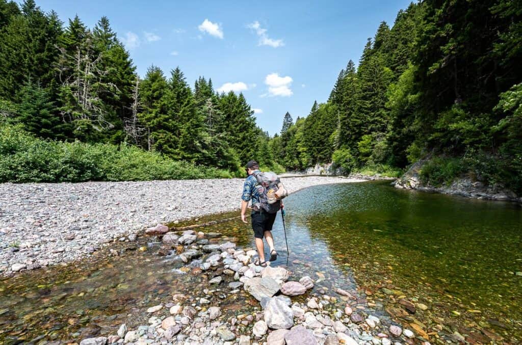 Patrick, the second guide working is way up the Little Salmon River by walking through the water and rock hopping