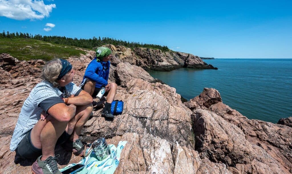 Enjoying lunch on colourful cliffs overlooking the Bay of Fundy on the Chance Harbour to Black Beach kayaking trip